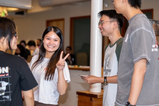An attendee flashing a peace sign while catching up with friends