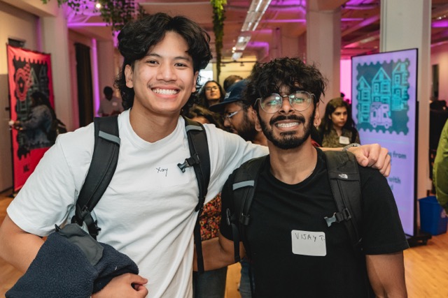 Two attendees arm in arm, all smiles at their Fest